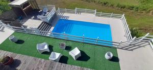 an overhead view of a swimming pool with white chairs at SLEMAN Franck in Les Anses-dʼArlets