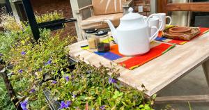 ein Tisch mit einem Teekessel und Gläsern darauf in der Unterkunft Pine Cone Cottages, Ella in Ella + 59 Fotos