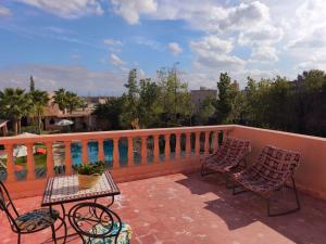 a patio with two chairs and a table on a balcony at Villa Essalah & Spa Marrakech in Marrakech