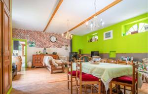 een eetkamer met groene muren en een tafel en stoelen bij Ancien Moulin Restauré in Clerques