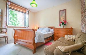 een slaapkamer met een bed en een bank bij Ancien Moulin Restauré in Clerques