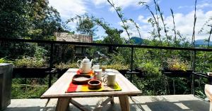 einen Holztisch mit einem Tablett mit Essen drauf in der Unterkunft Pine Cone Cottages, Ella in Ella