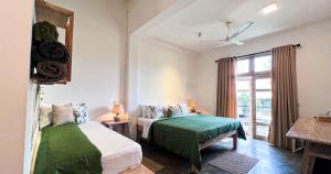 ein Schlafzimmer mit zwei Betten und einem Fenster in der Unterkunft Pine Cone Cottages, Ella in Ella