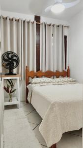 ein Schlafzimmer mit einem Bett und einem Fenster mit Vorhängen in der Unterkunft Casa a 100mts da praia in Ilhabela