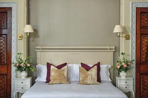 a bedroom with a white bed with pillows and flowers at Buxted Park Hotel in Uckfield +49 photos