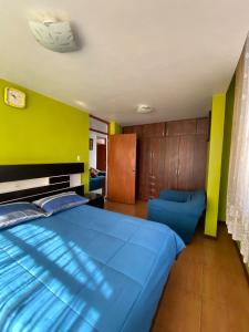 阿雷基帕Casa Acogedora de Estilo Clásico的卧室里有一张蓝色的床和一面绿色的墙 更多35张照片