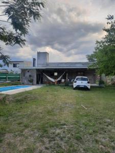 ein Auto, das auf einem Hof vor einem Haus parkt in der Unterkunft Casa vacacional con pileta y quincho - El Mollar I Salta in Cerrillos