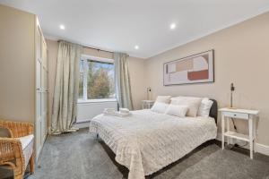 a bedroom with a large bed and a window at Lovely Ealing 3 Bed Flat in Ealing +5 photos