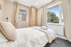 a bedroom with a white bed and a window at Lovely Ealing 3 Bed Flat in Ealing