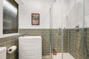 a bathroom with a glass shower with a toilet and a sink at Lovely Ealing 3 Bed Flat in Ealing