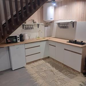 a kitchen with white cabinets and a rug on the floor at GORY & TYSHA Гори і Тиша in Yavoriv