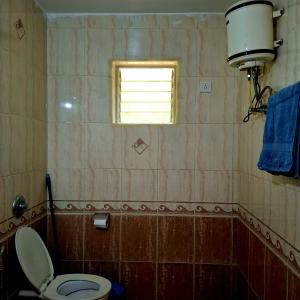 ein Badezimmer mit Toilette und Fenster in der Unterkunft Casa de Palmora 103 in Canacona + 1 Foto