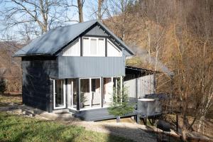 a small house with a black roof and windows at Гори і тиша gory & tysha in Yavoriv