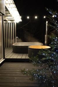 eine Badewanne, die nachts auf einem Deck sitzt in der Unterkunft GORY & TYSHA Гори і Тиша in Yavoriv