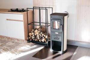 a stove with a pile of wood in a room at GORY & TYSHA Гори і Тиша in Yavoriv