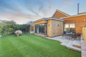 a backyard with a wooden house and a lawn at 2 Bed in Snape oc-sfvin in Snape