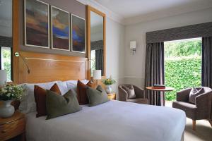 a bedroom with a large white bed and a chair at Buxted Park Hotel in Uckfield