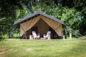 a tent with two chairs and a table in it at Dromquinna Manor in Dunkerron Islands +8 photos