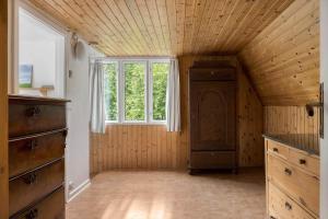 an attic room with a dresser and a window at HAL657-Knaered-Bjoerkered-72 in Körsveka