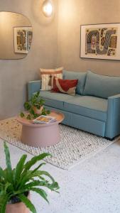 een woonkamer met een blauwe bank en een tafel bij La Colmena in Mexico-Stad