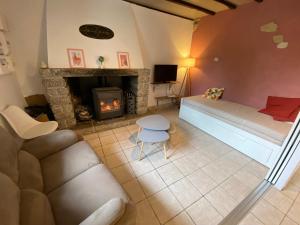 un salon avec un canapé et une cheminée dans l'établissement La maison Callinora, à La Chapelle-Saint-Étienne