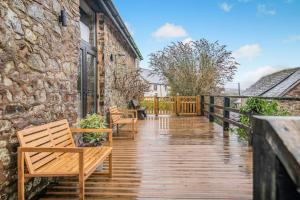 a wooden deck with benches and a building at 3 Bed in Dulverton oc-t32975 in Dulverton