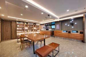 a library with a wooden table and chairs and shelves at Hanting Premium Hotel Shanghai Pudong Airport Chenyang Road in Shanghai