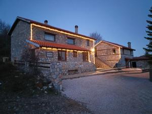 a stone house with lights on the front of it at Forest House in Palaios Agios Athanasios