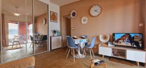 Una sala de estar con una mesa y un reloj en la pared. en Ti Ker Créole, en Saint-Benoît