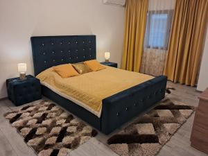 una camera da letto con un letto con una struttura blu e un tappeto di Apartament NECTARIA a Băile Herculane