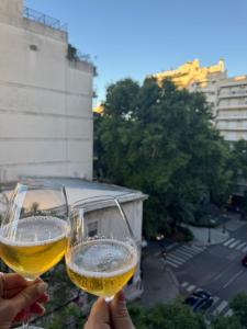 a person holding two glasses of wine at Canela Loft Rosario in Rosario