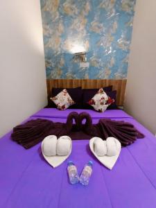 ein Bett mit zwei Herzen und zwei Paar Schuhe in der Unterkunft Ketapang Residence Hotel in Jakarta