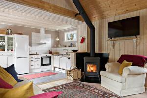 eine Küche mit einem Herd und ein Wohnzimmer mit einem Kamin in der Unterkunft JON544 Ramkvilla - Kyrkotorp 0 in Ramkvilla