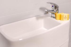a white bathroom sink with a yellow box on it at 1 Bed in Four Lanes oc-b32769 in Carnbrea