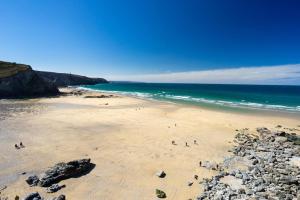 a group of people walking on a beach at 1 Bed in Four Lanes oc-b32769 in Carnbrea +6 photos
