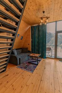 una sala de estar con un sofá y una mesa en Vista cottage, en Kazbegi