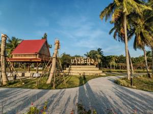 a road leading to the entrance to a resort with palm trees at Windy Pool Villa Pattaya 3 King size bedrooms in Ban Bang Lamung
