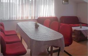 a waiting room with a table and red chairs at 3 Bedroom Lovely Apartment In Rogotin-Ploce in Rogotin