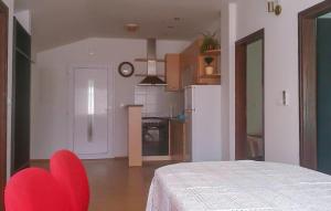 a kitchen with a red chair in a room at 3 Bedroom Lovely Apartment In Rogotin-Ploce in Rogotin