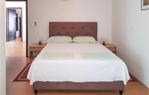 a bedroom with a large white bed with two tables at 3 Bedroom Lovely Apartment In Rogotin-Ploce in Rogotin