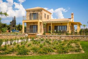 a house with a garden in front of it at Orion Luxury Villa in Svoronata