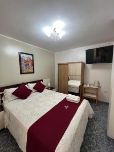 Un dormitorio con una cama grande con almohadas rojas. en HOTEL AREQUIPA, en Nazca