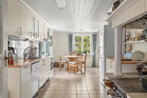 a kitchen with white cabinets and a table with chairs at KAL558-Virserum-Holm-6 in Holm