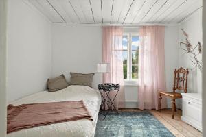 a white bedroom with a bed and a window at KAL558-Virserum-Holm-6 in Holm