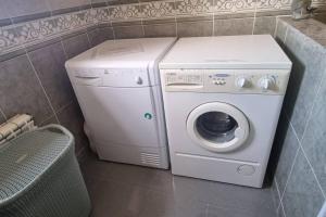 Una lavadora y secadora blancas en un baño. en La Ayalga casa de campo, en Ardisana