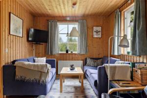 KRO431-Lidhult-Odensjoe-Torsborg-1 في Löckna: غرفة معيشة مع أريكة زرقاء وطاولة