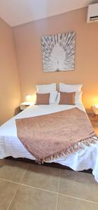 Un dormitorio con una cama grande con sábanas y almohadas blancas. en Ti Ker Créole, en Saint-Benoît