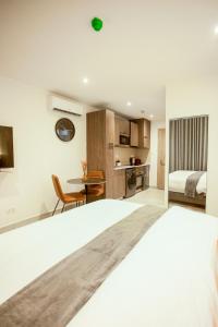 a bedroom with a bed and a desk and a kitchen at Accra Luxury Apartments at The Bantree in Accra