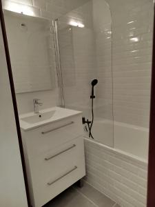 a white bathroom with a sink and a shower at Charmant appartement de montagne avec balcon in Mijoux +12 photos