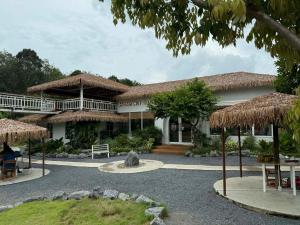 a house with a thatched roof and a patio at Hidden Haven Resort Koh Lanta in Ko Lanta